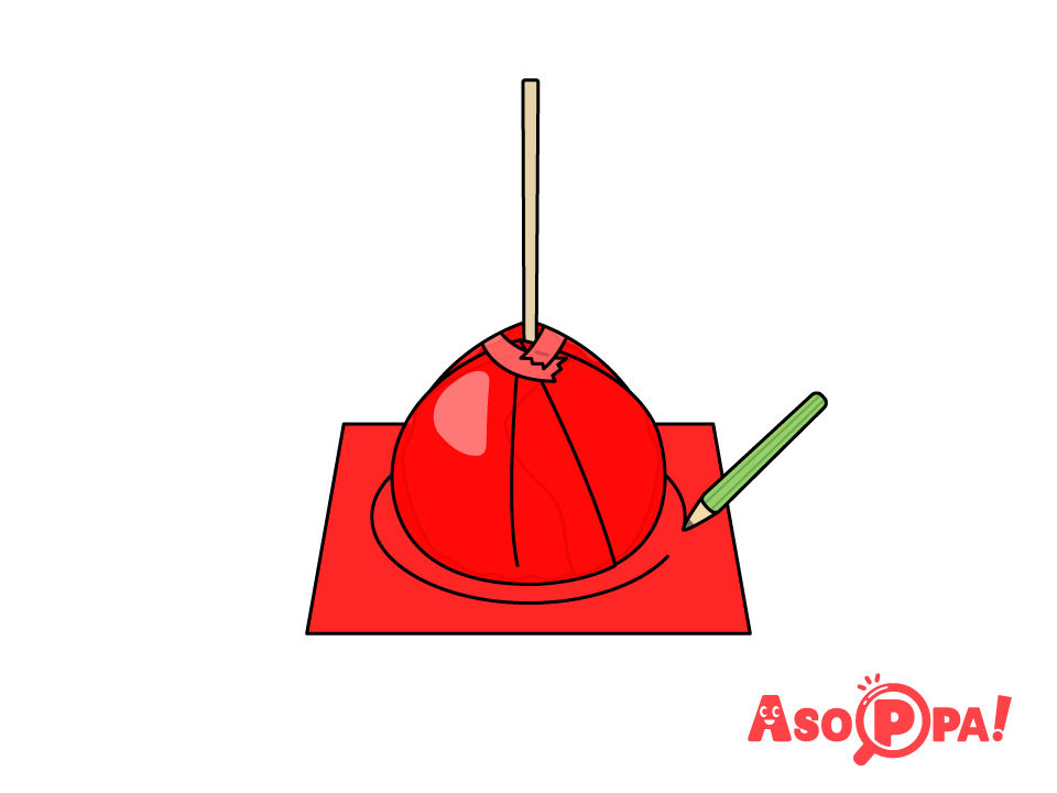 赤の色画用紙をりんご飴の底に合わせ、底より少し大きい円を描く。