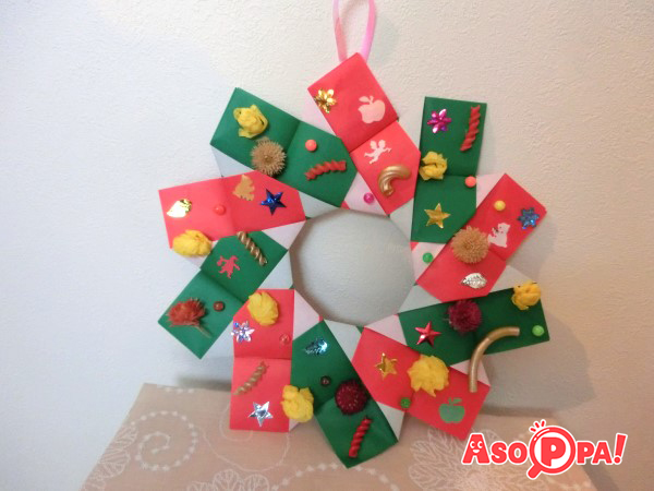 木工用ボンド（折り紙であればのりでも可）で飾りを付けます。リース裏にテープでひもを付けると、折り紙で作るクリスマスリースのできあがりです！